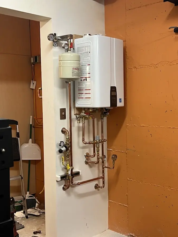 Plumbing technician inspecting water heater connections in Yukon